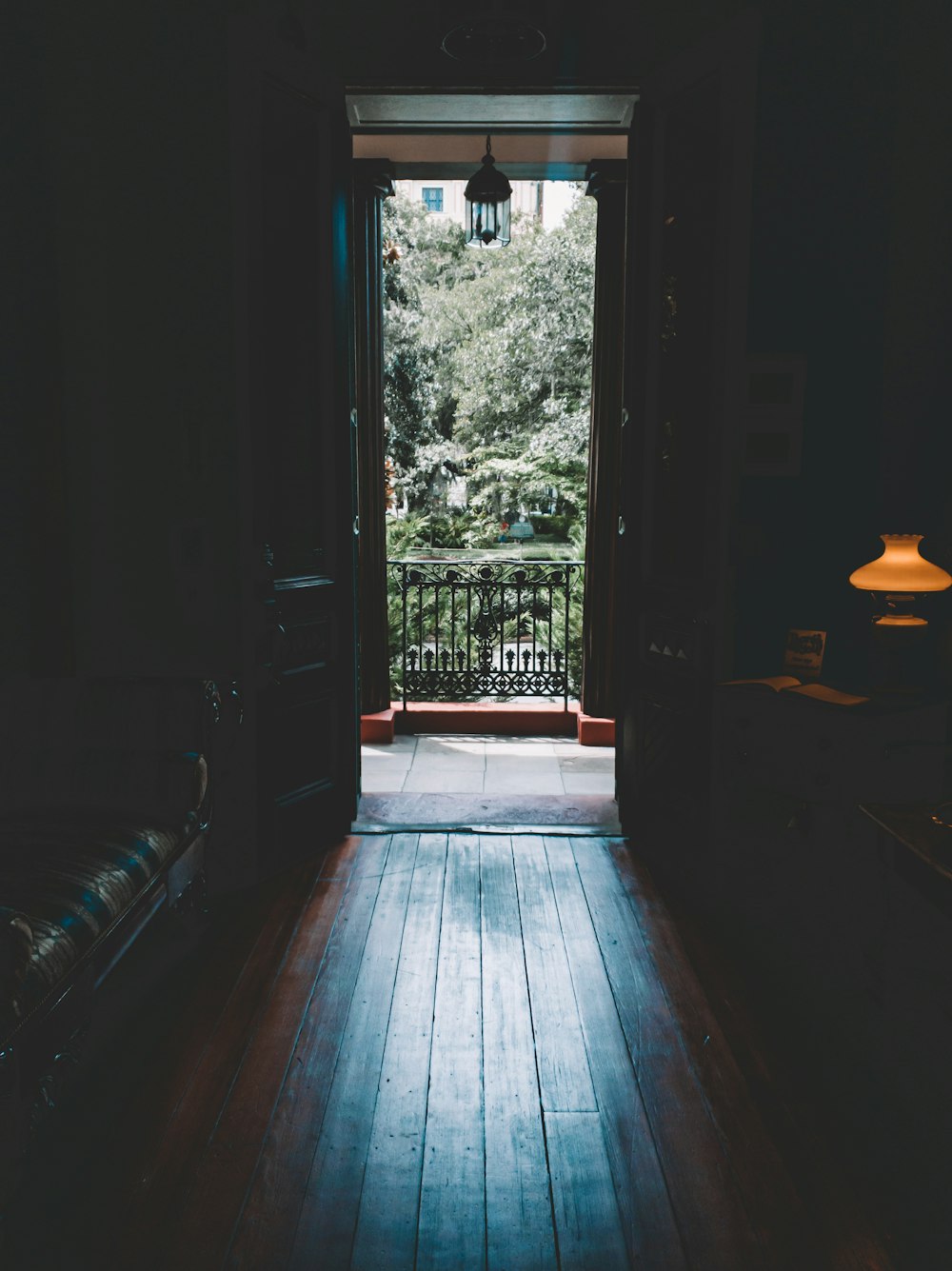 a wooden walkway with a lamp on the side