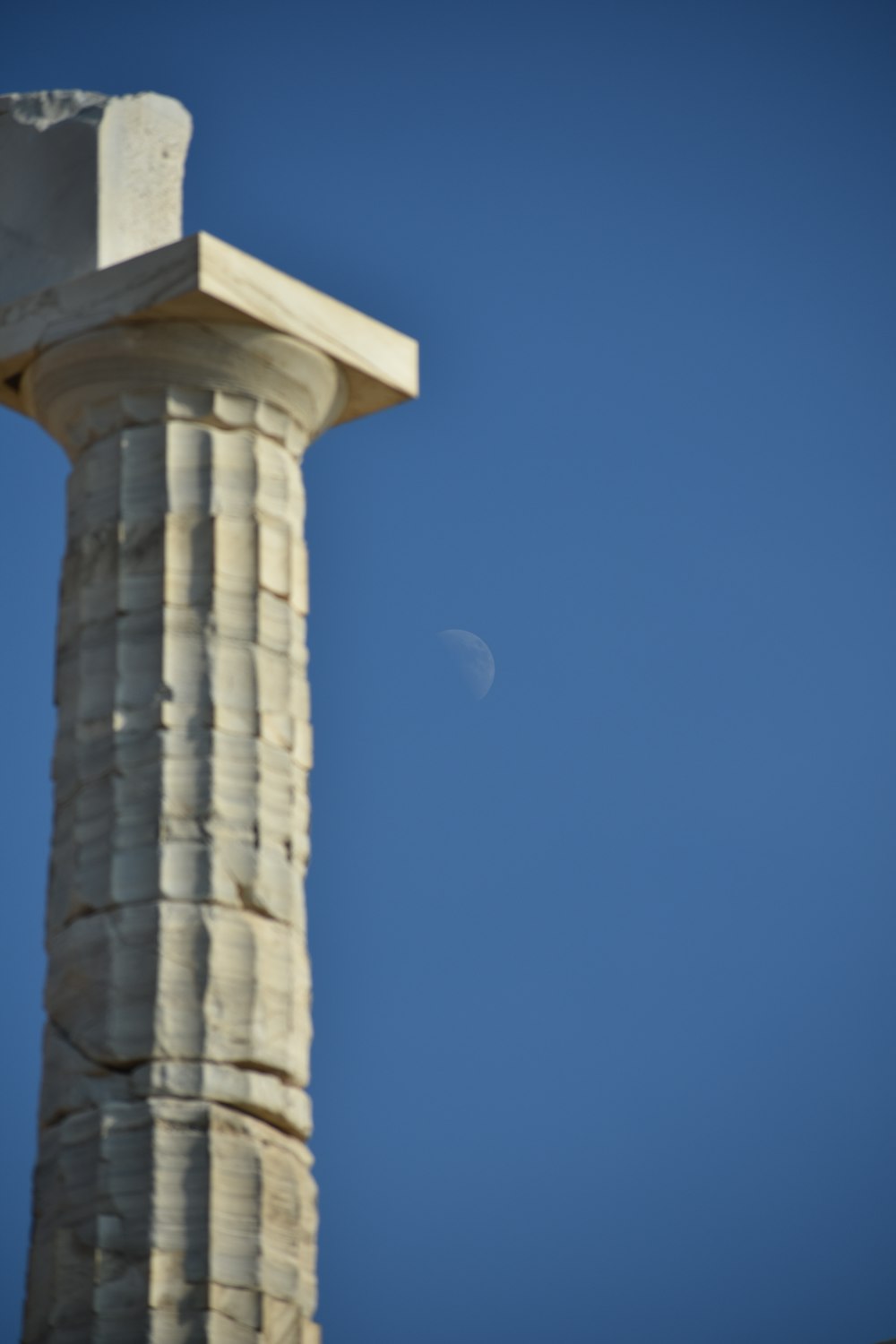 a tall stone tower with a moon in the sky