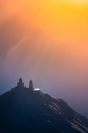 A serene sunrise over a quiet church with worshippers raising their hands in praise.