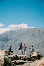 A group of diverse travelers enjoying a scenic view together on a mountain top.