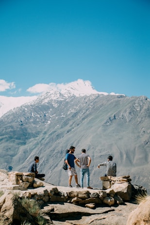 A group of diverse travelers enjoying a scenic view together on a mountain top.