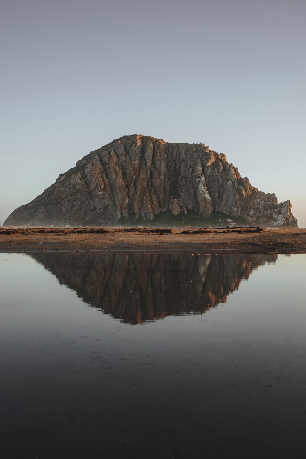 a body of water with a rocky mountain in the background