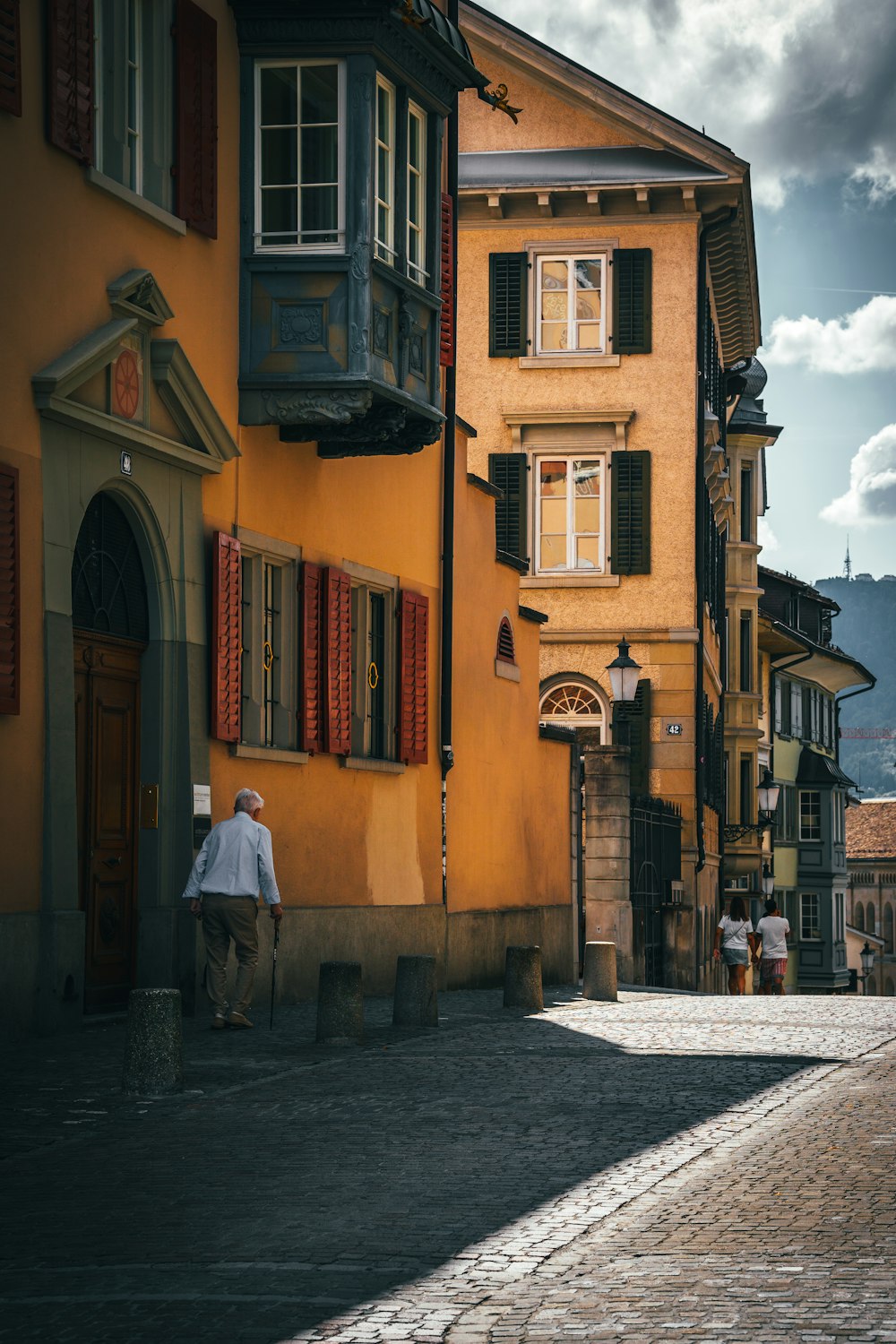 a person walking down a cobblestone street between buildings