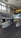 A metallic aircraft featuring a distinctive design with two drop tanks under the wings is inside a hangar. The aircraft showcases a polished, reflective surface with markings. The hangar has a high ceiling with large windows allowing natural light to illuminate the space.