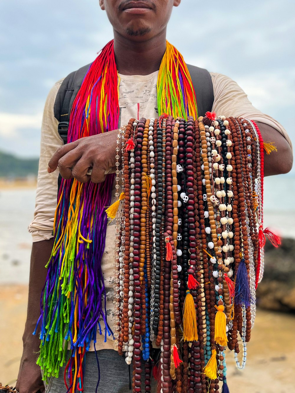 a man holding a bunch of colorful beads