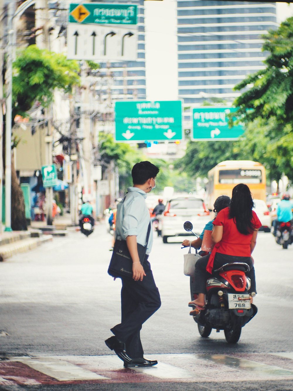 a man and a woman on a scooter on a busy street