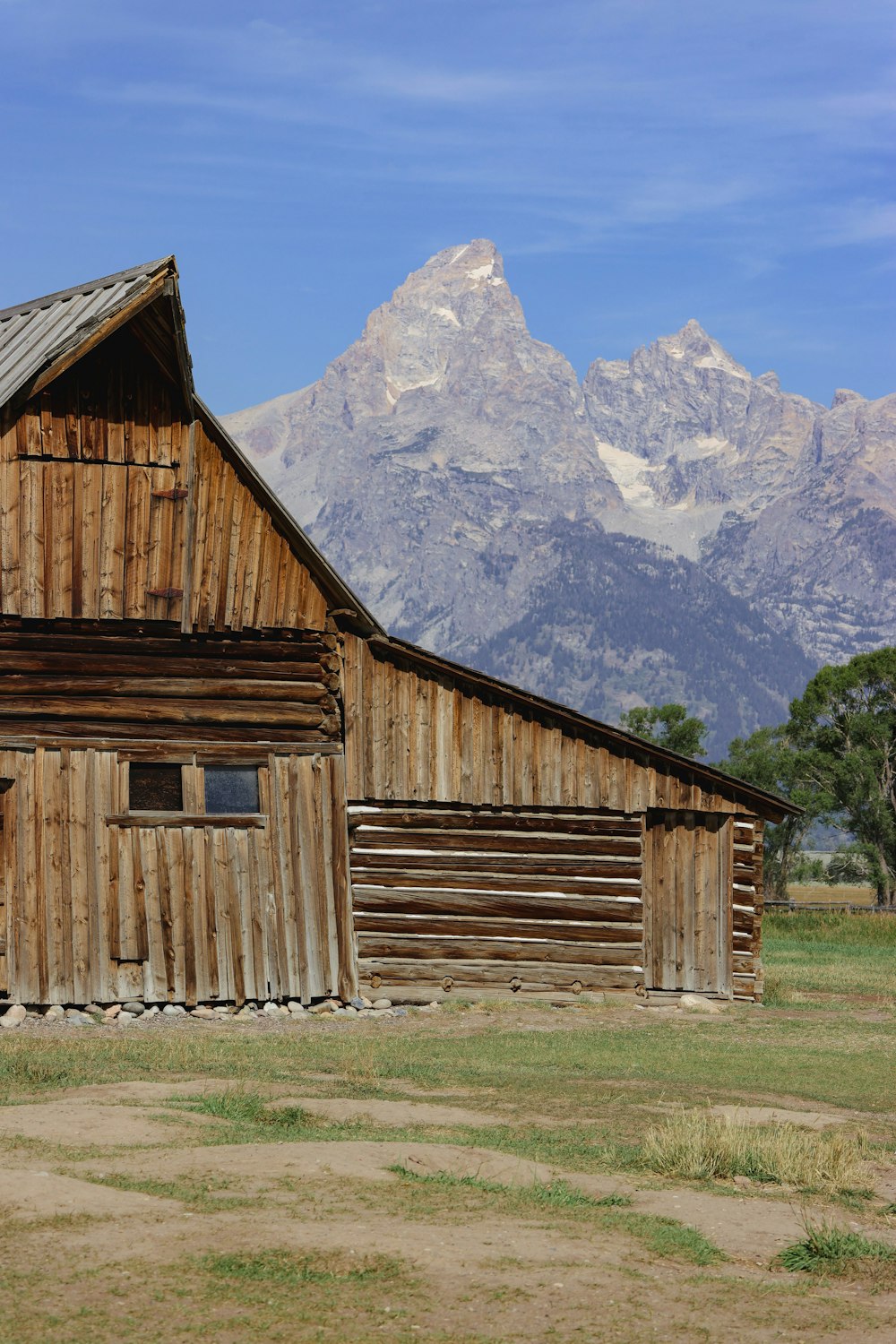 a wooden building with a mountain in the background