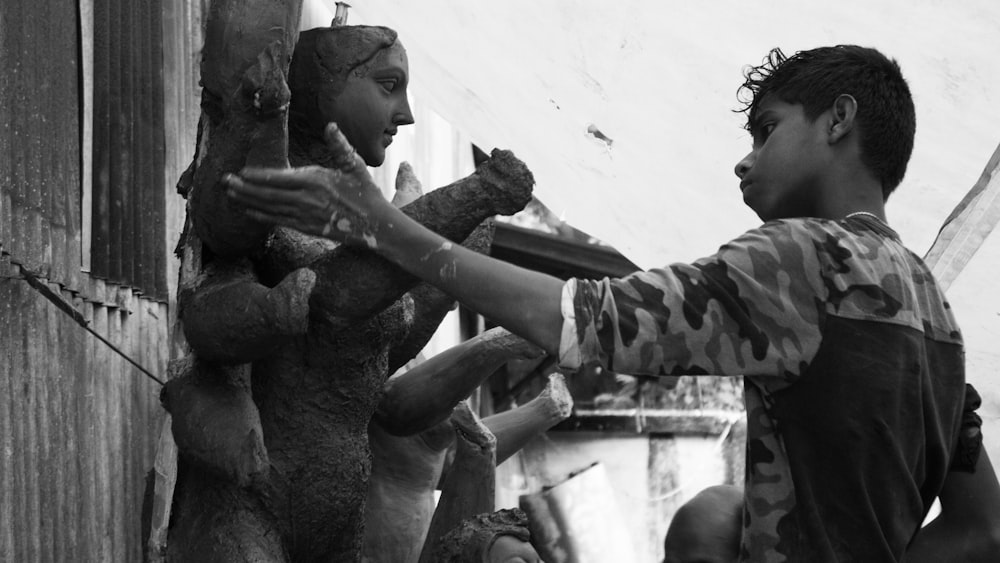 a man touching a statue