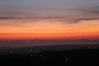 Sunset hues painting the sky above the distant hills visible from Elangoli Homestay.
