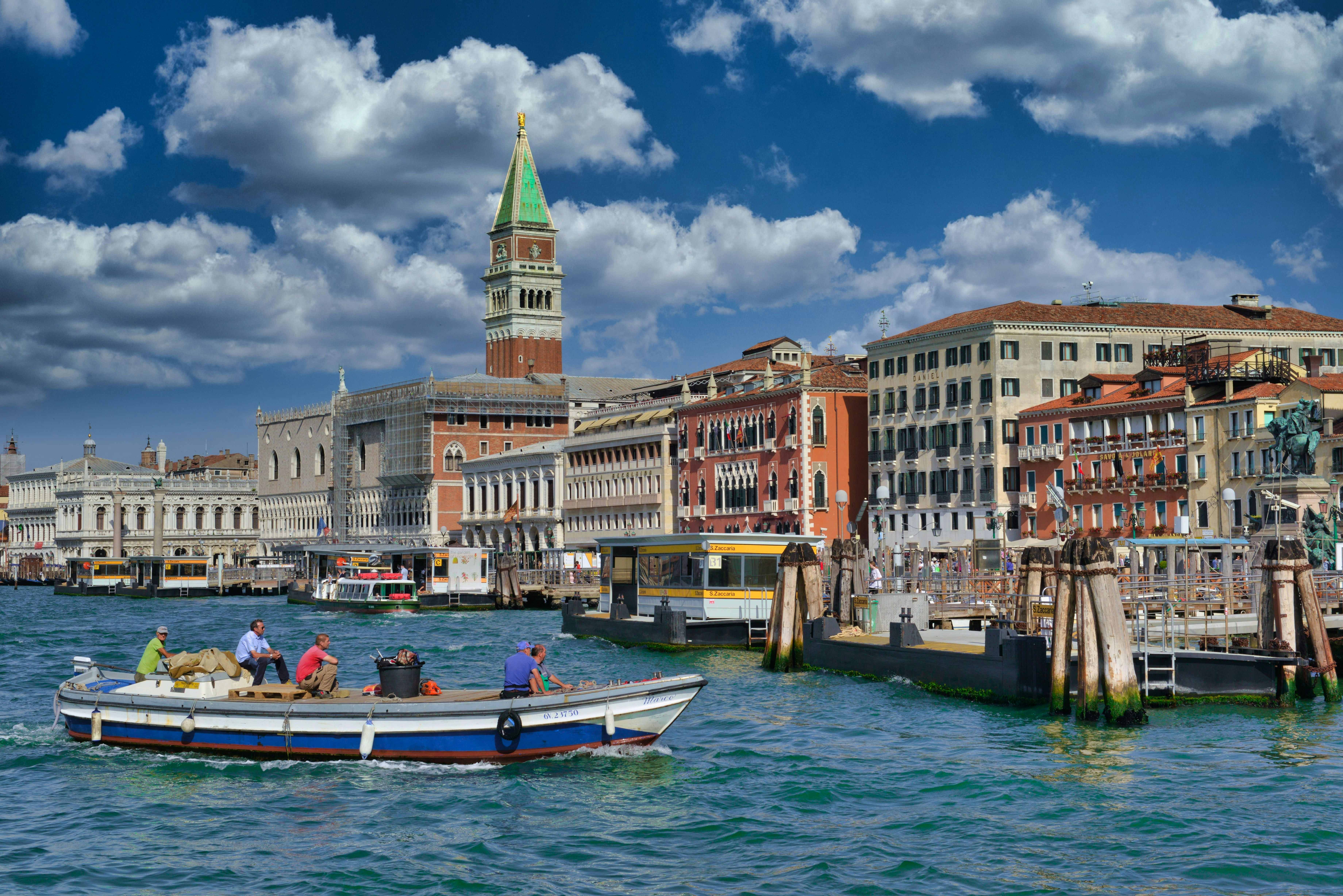 a group of people on a boat in a body of water, Venice in summer time, Italy