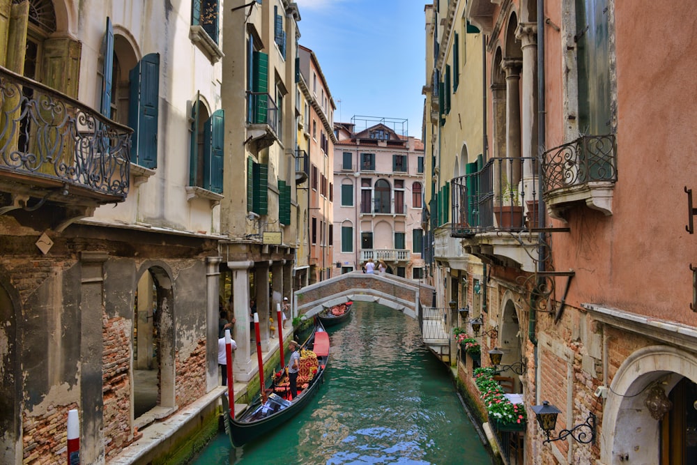 a boat on a canal between buildings