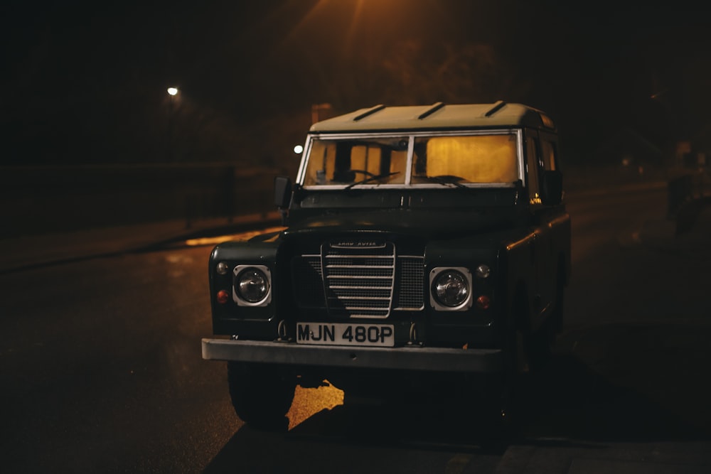 a black truck on a road at night