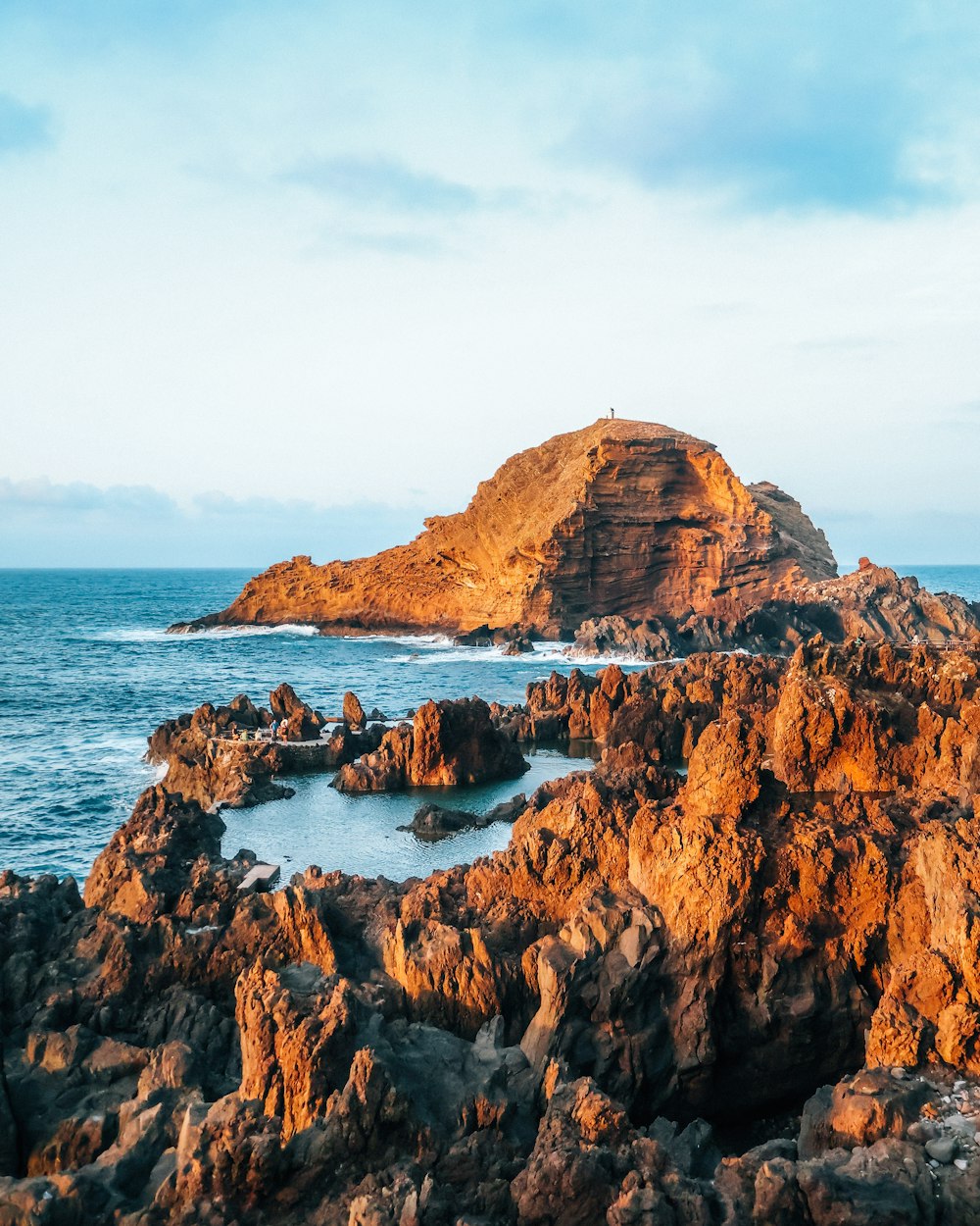 a rocky cliff next to the ocean