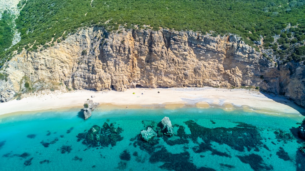 a rocky cliff with a body of water below