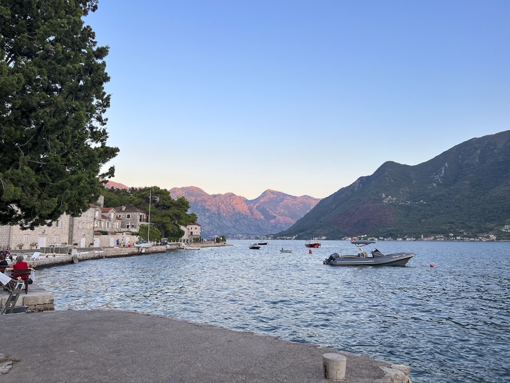 a body of water with boats and mountains in the background