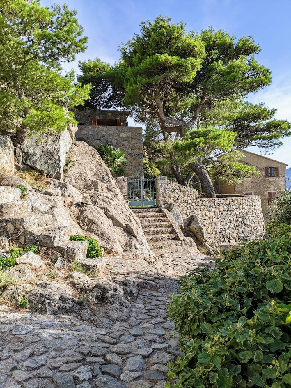 a stone building with a tree and stairs