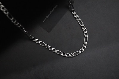 Close-up of a silver chain with subtle reflections, floating in zero gravity.