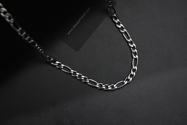 Close-up of a finely crafted solid silver chain with intricate links catching the light.