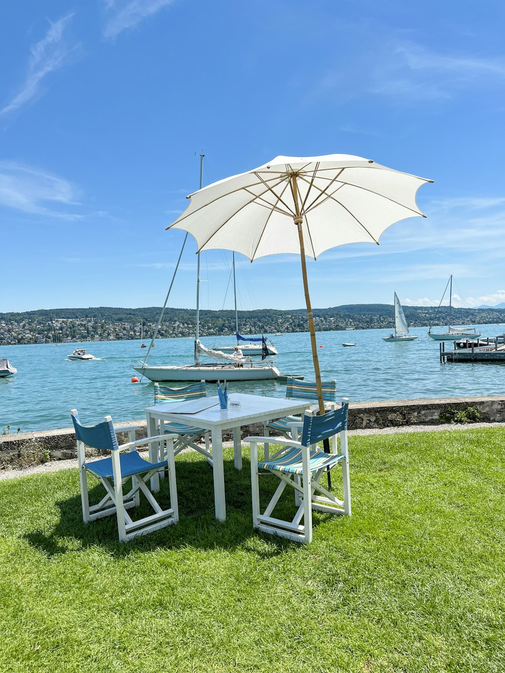 a table and chairs next to a body of water