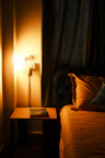 Cozy corner of the AC room showing a bedside lamp and soft pillows.