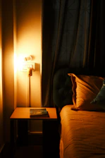 A cozy night scene showing a person reading in bed with the Onwave LED bookmark emitting a warm amber glow.