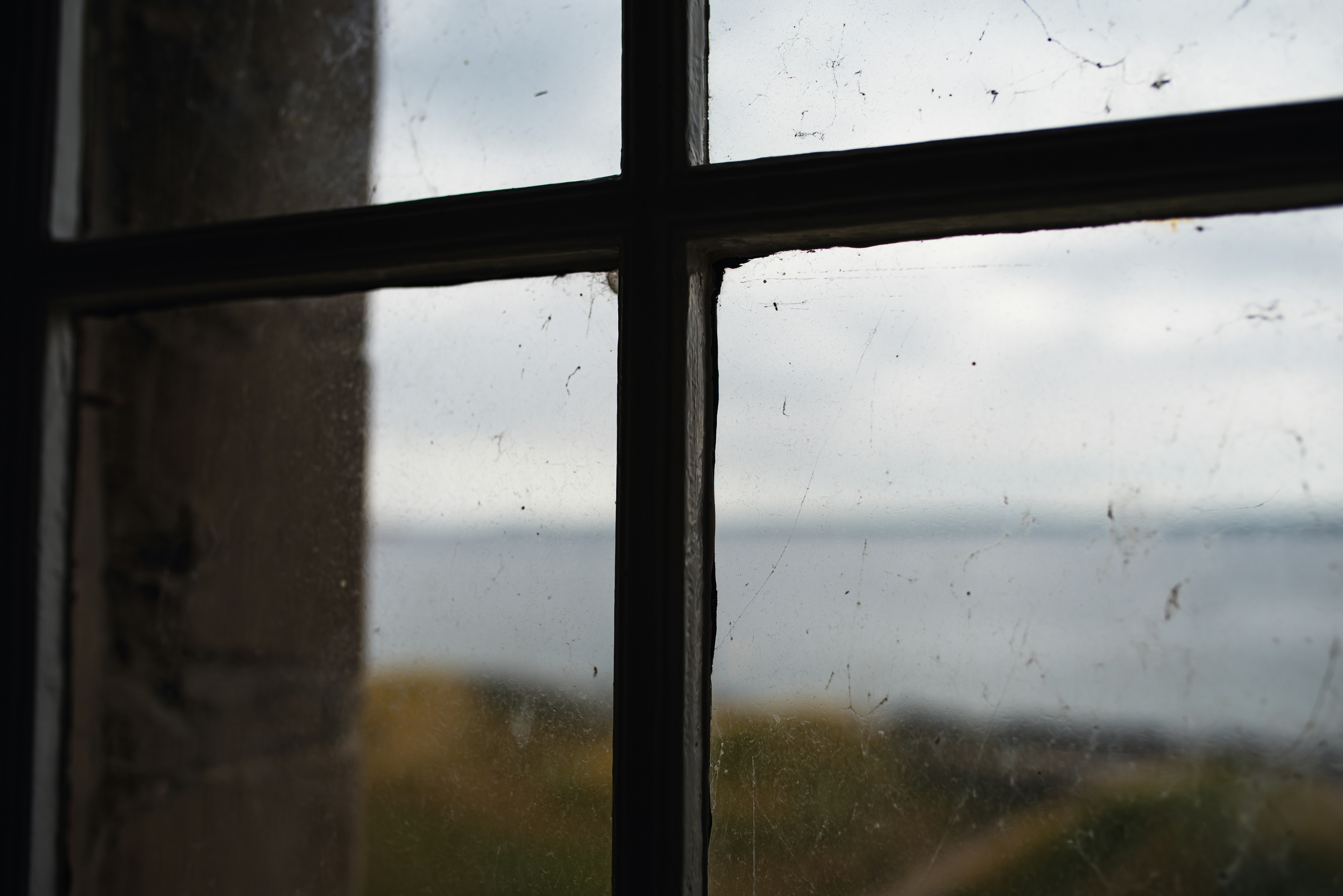 window frame in foreground, looking at grey sky outside
