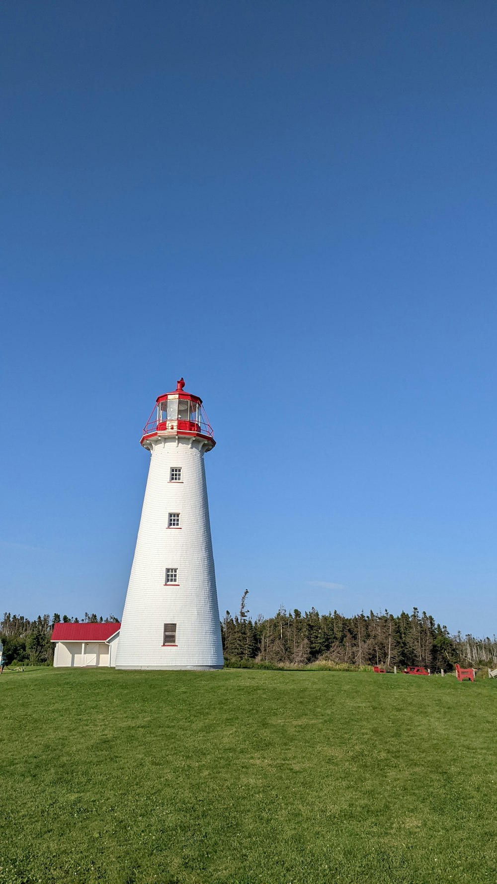 um farol em uma colina gramada