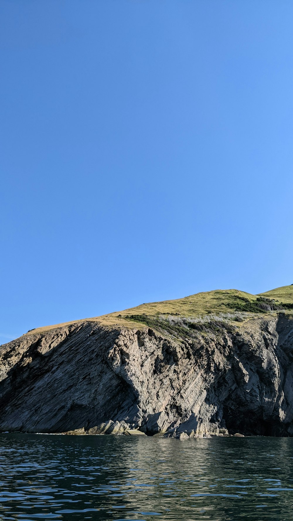 a cliff next to a body of water