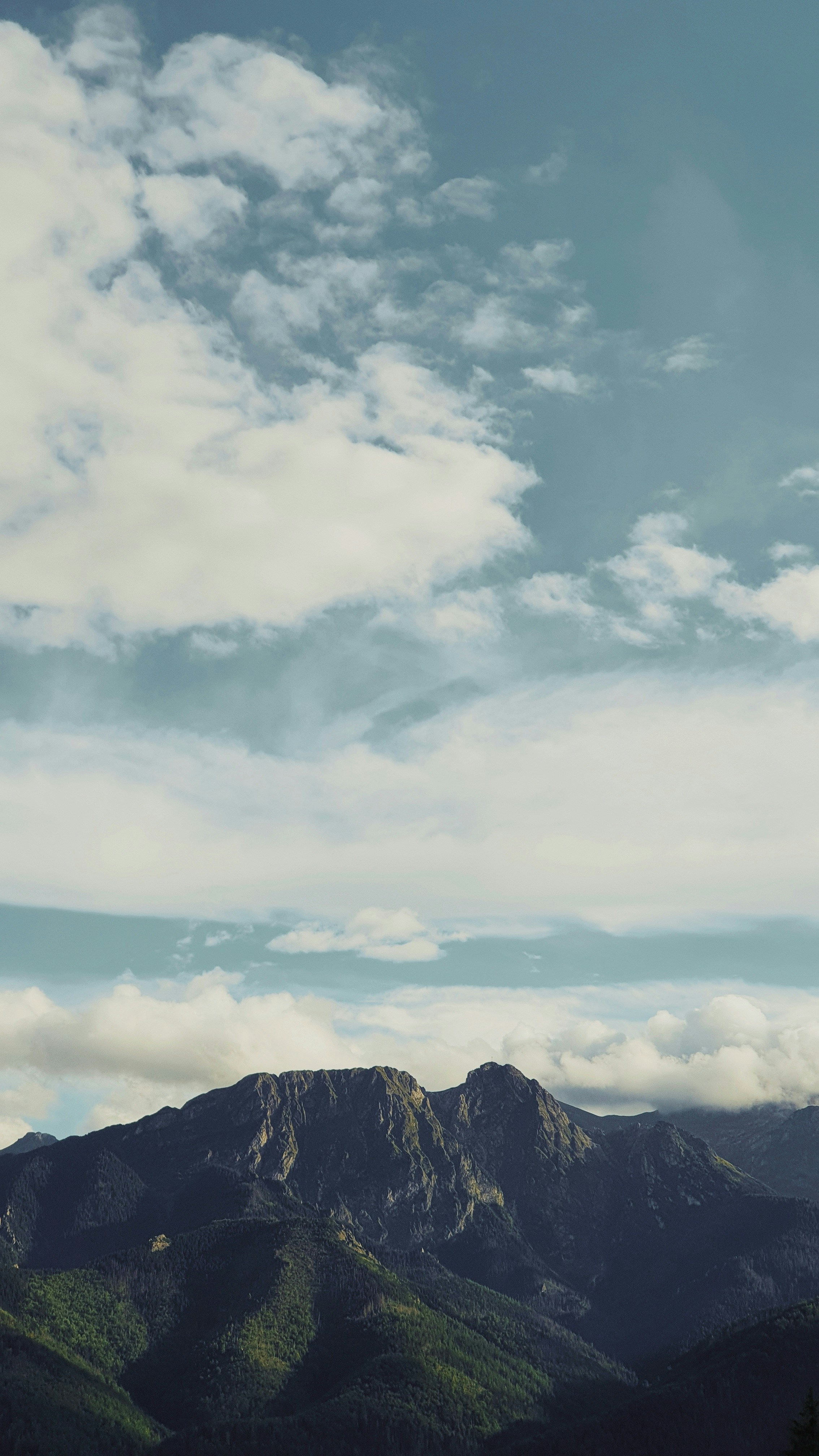 a mountain with clouds above it