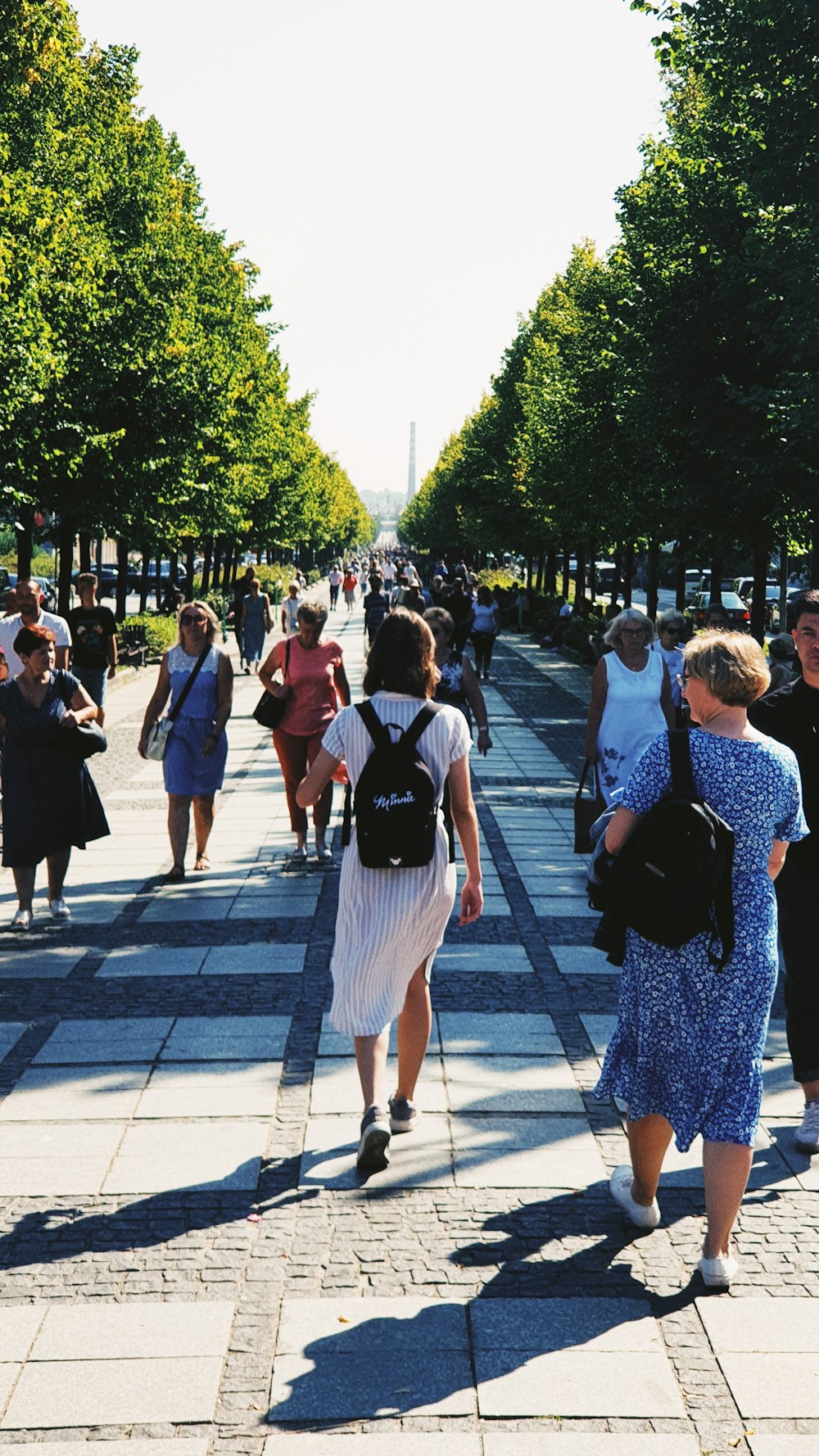 a group of people walking on a sidewalk