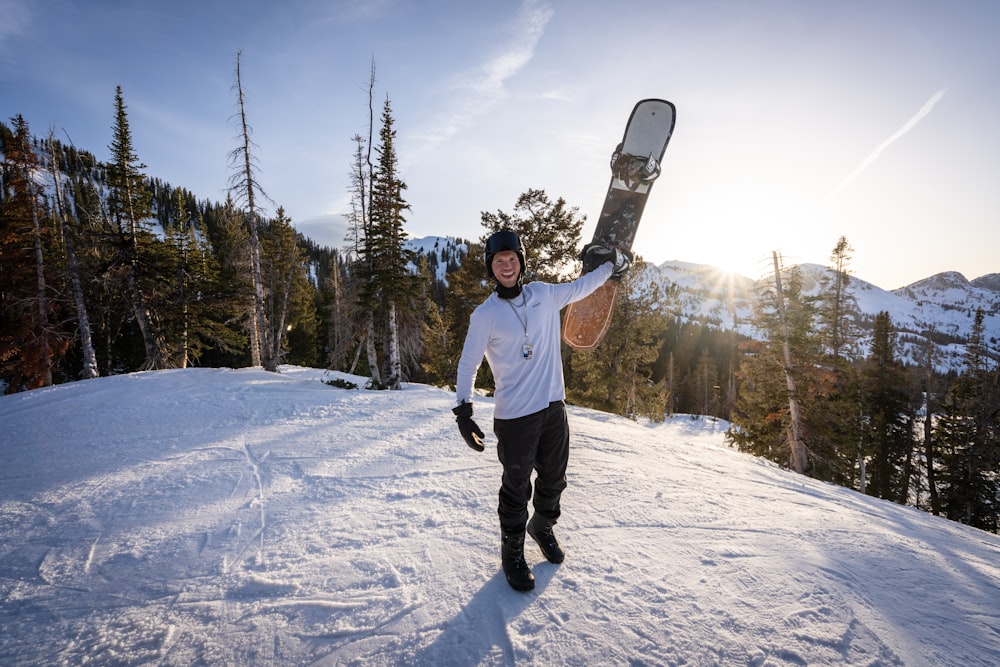 um homem segurando uma prancha de snowboard