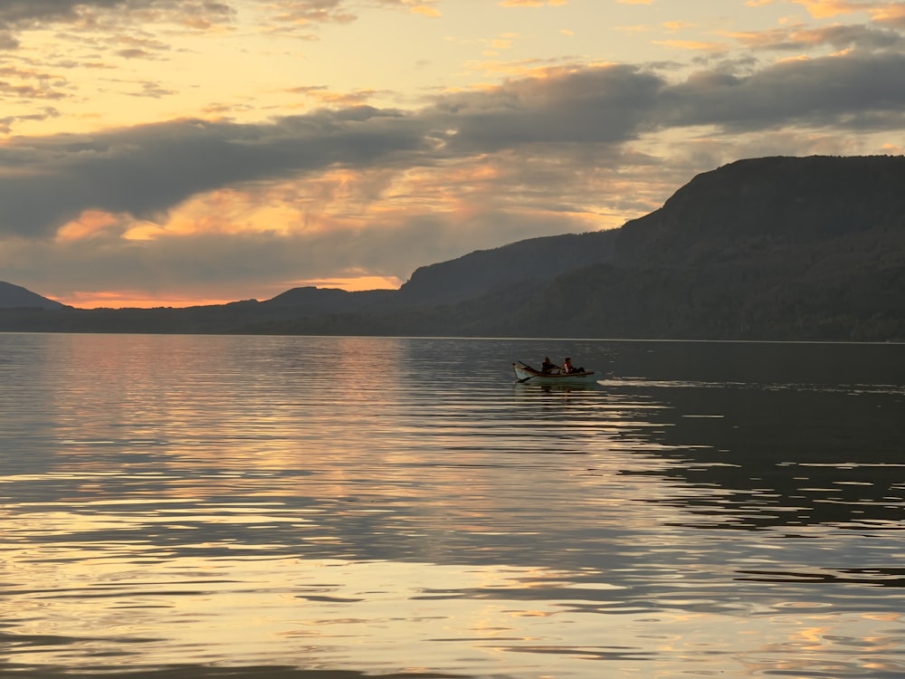 a couple people in a boat on a lake