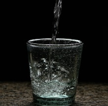 a glass of water with a black background