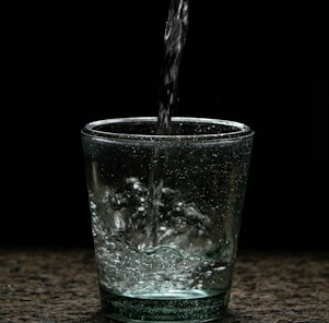 Bright kitchen scene showing crystal-clear water pouring into a glass.