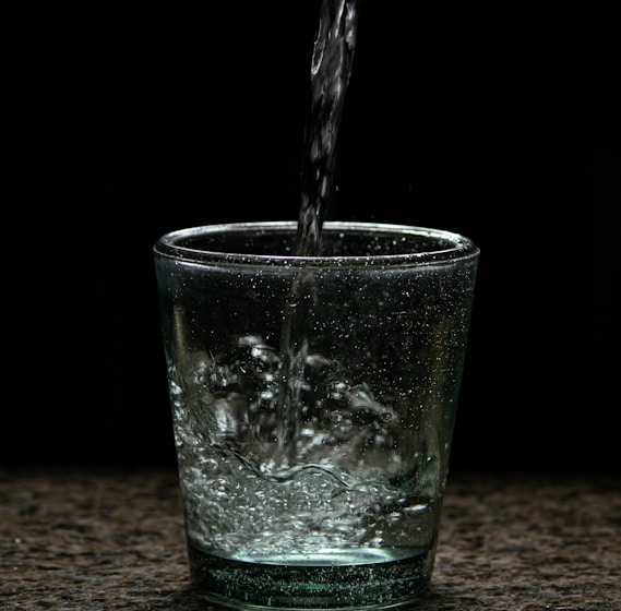 a glass of water with a black background