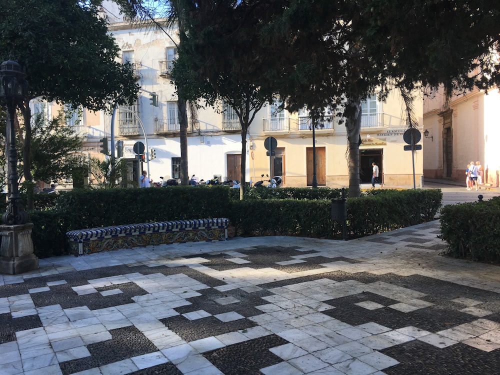 a brick walkway with trees and bushes