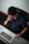 Man sitting at a desk with a laptop, gently massaging his eyes with a calm expression