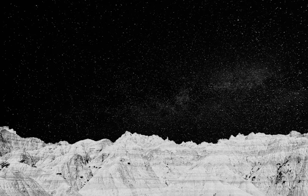 A twilight landscape featuring strange, ethereal rock formations under a starry sky.