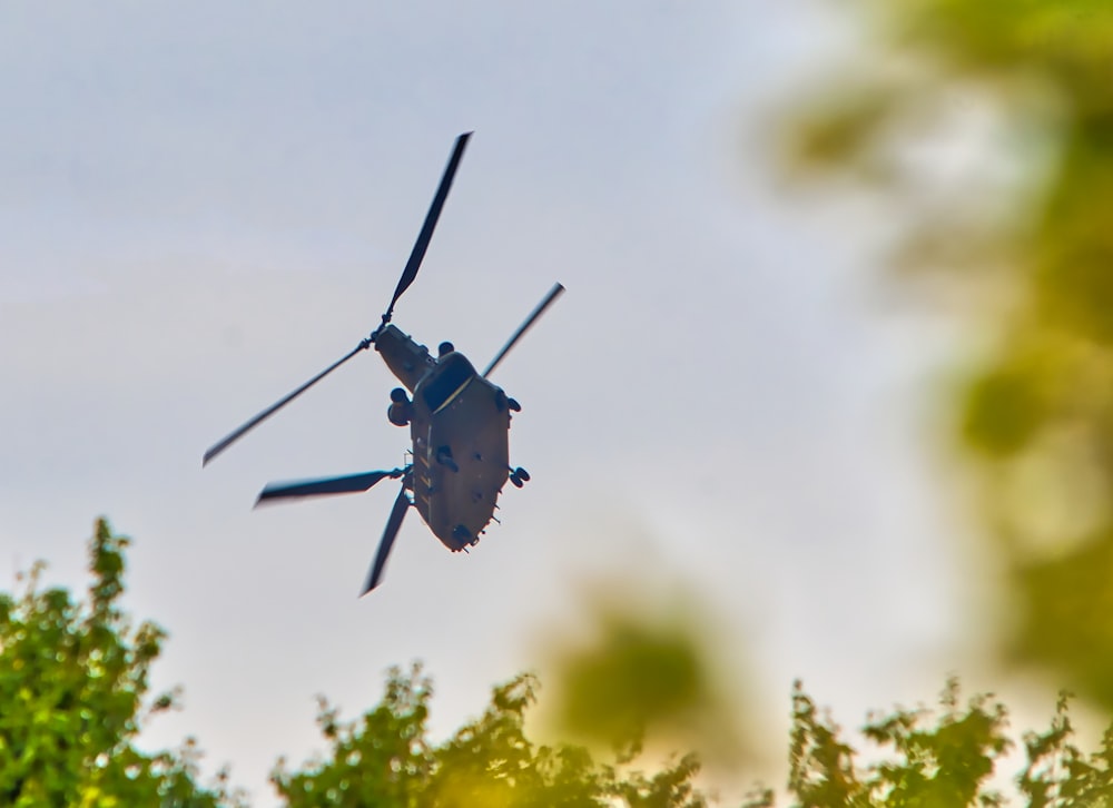 a helicopter flying over trees