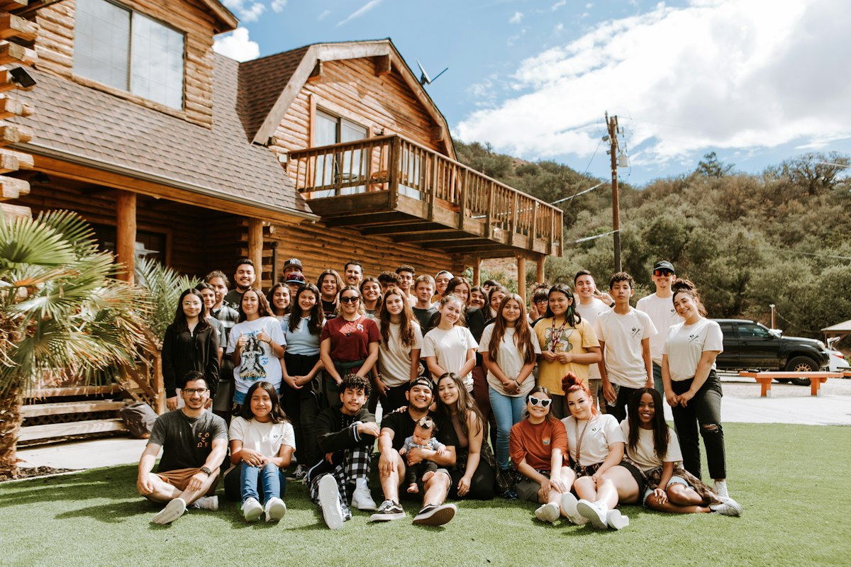 Group of friends gathered outside a large vacation home on a group trip