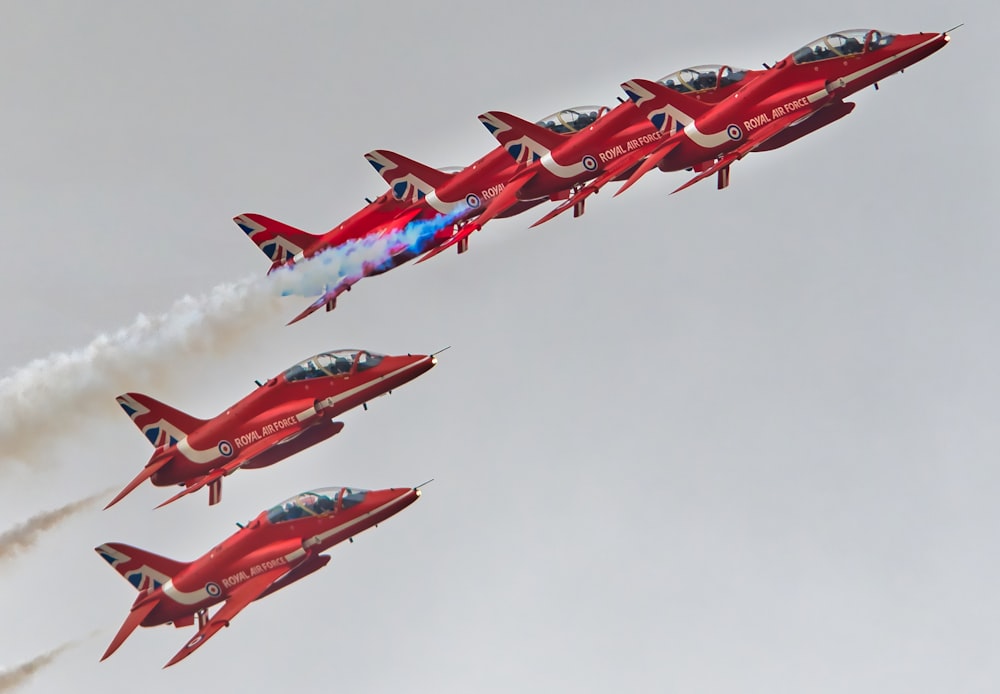 Un grupo de aviones rojos volando en el cielo