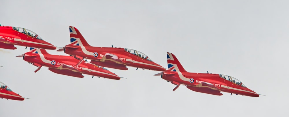 a group of red airplanes flying in the sky