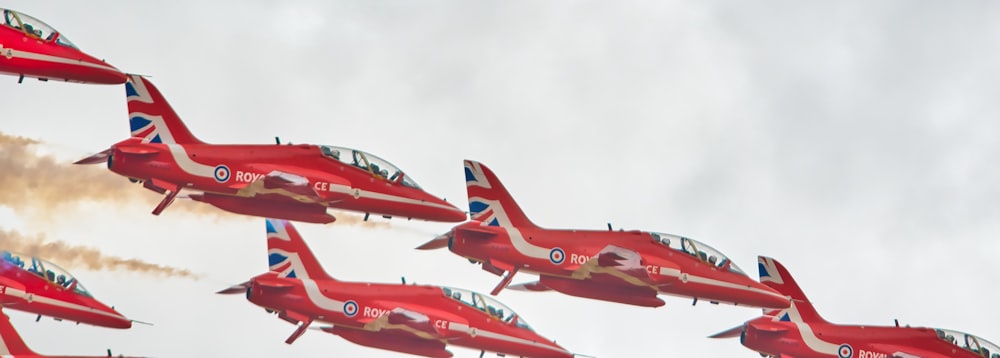 a group of red airplanes flying in the sky