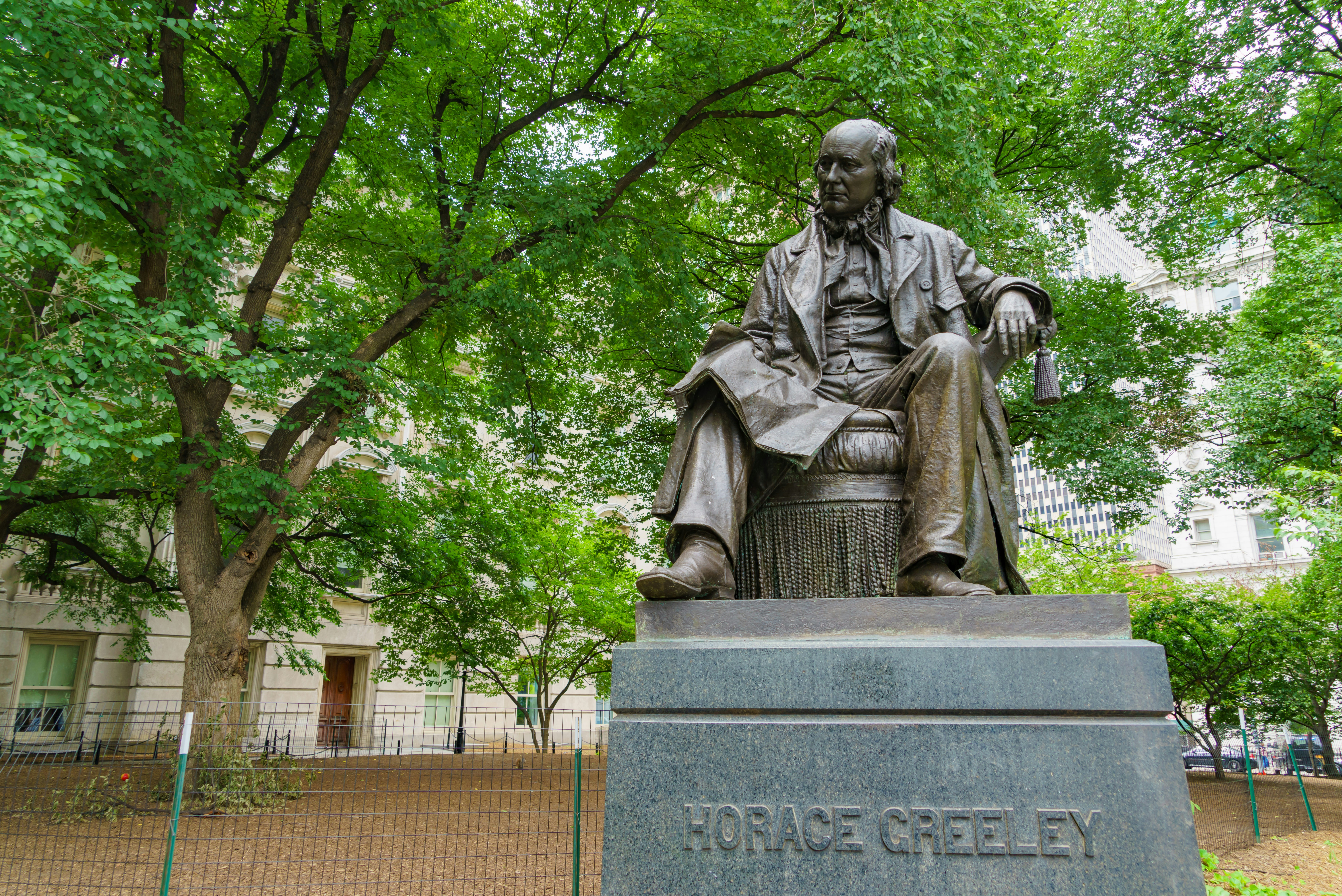 A statue of a man sitting on a stone bench