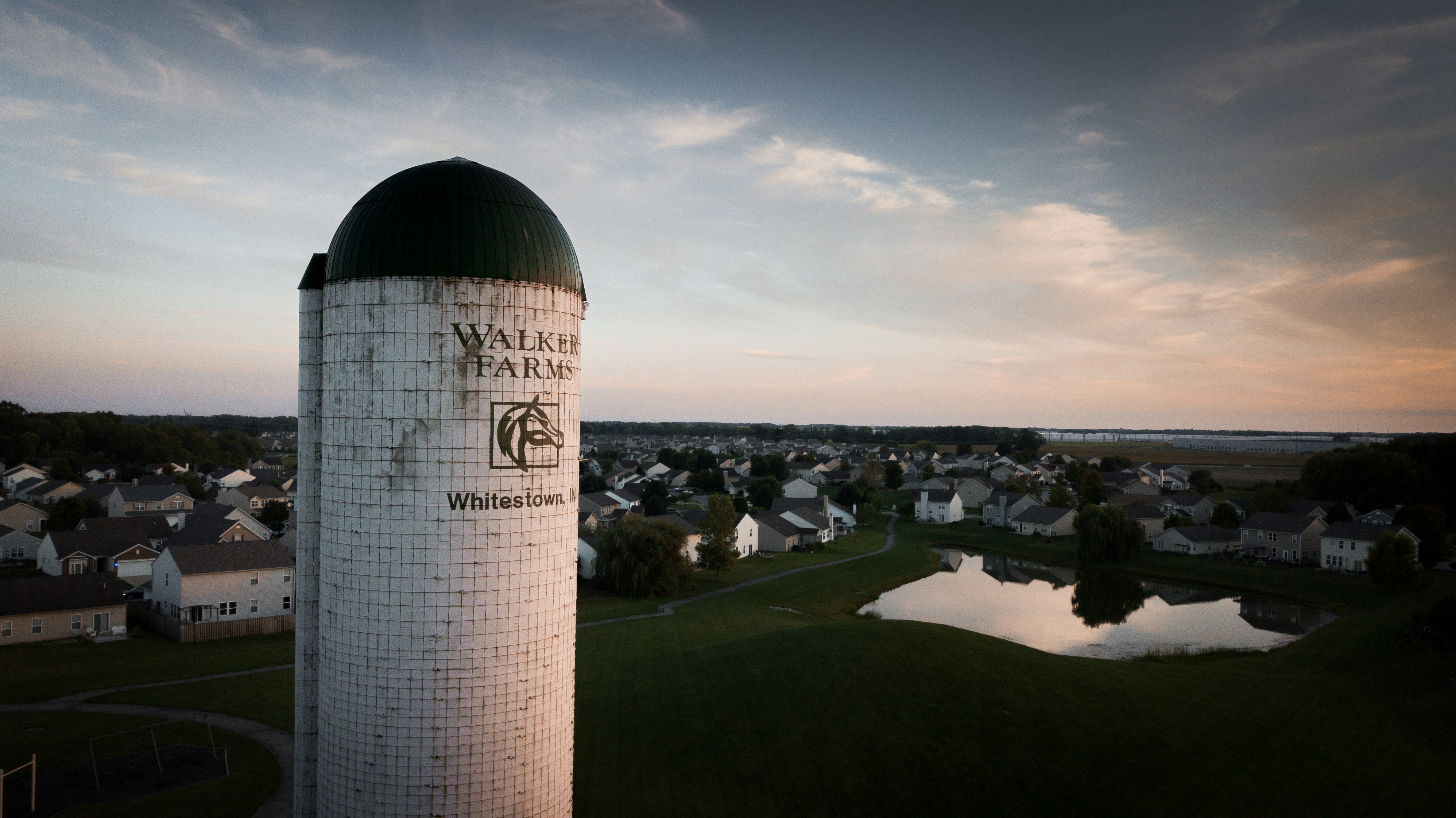 a large stone pillar with a dome on top and a town below