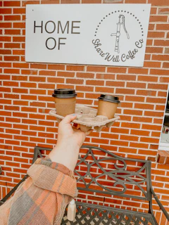 Close-up of hands exchanging a map and coffee at a bustling fleet hub café, embodying community spirit.