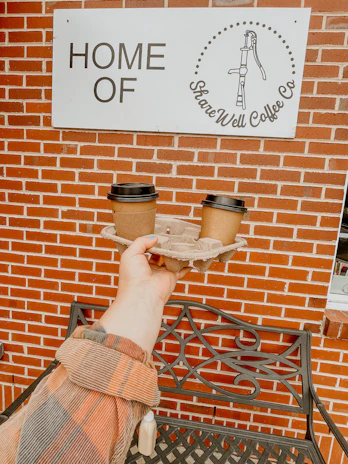 Close-up of hands exchanging a map and coffee at a bustling fleet hub café, embodying community spirit.