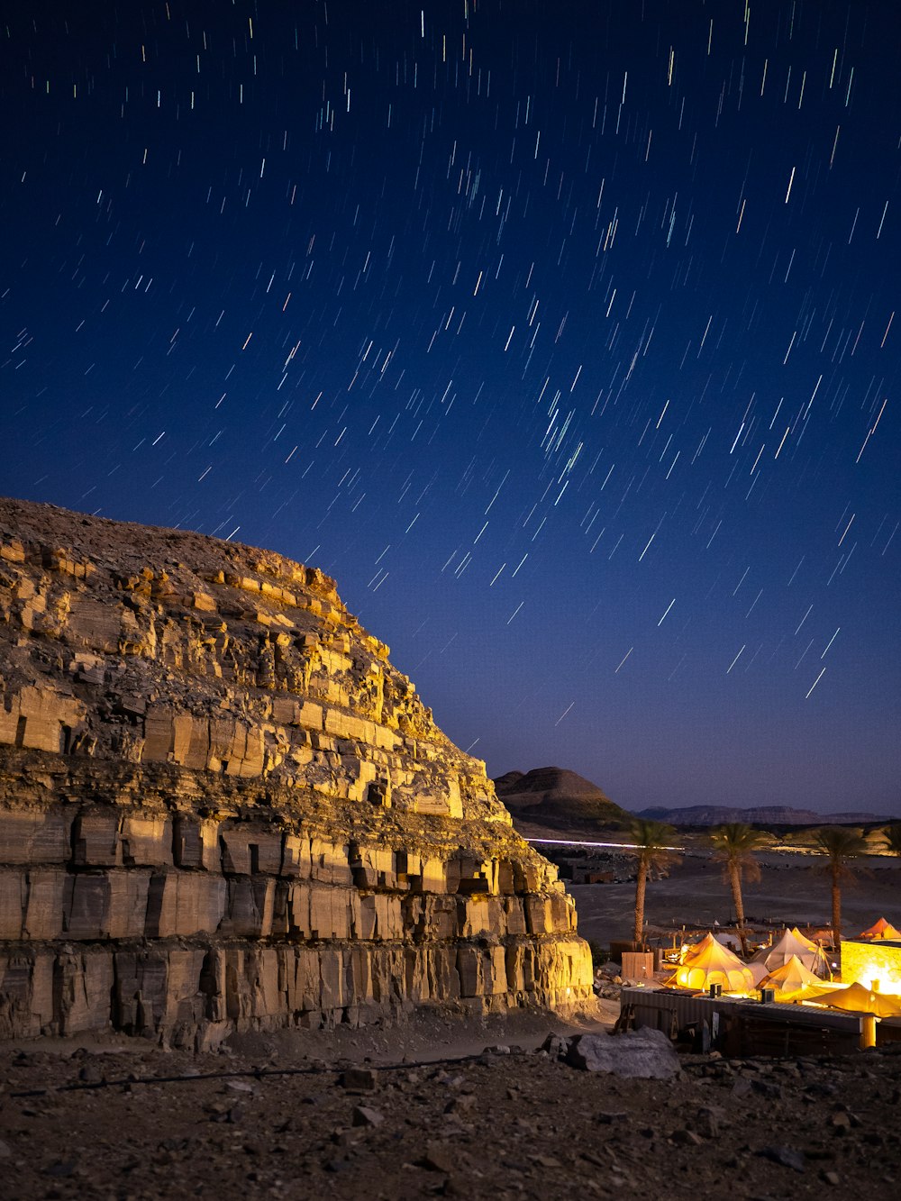 una gran roca con estrellas en el cielo sobre ella