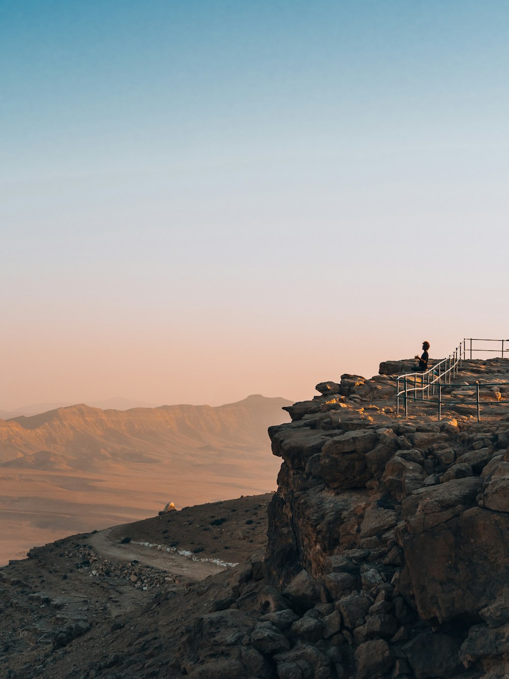 a person standing on a bridge over a rocky canyon