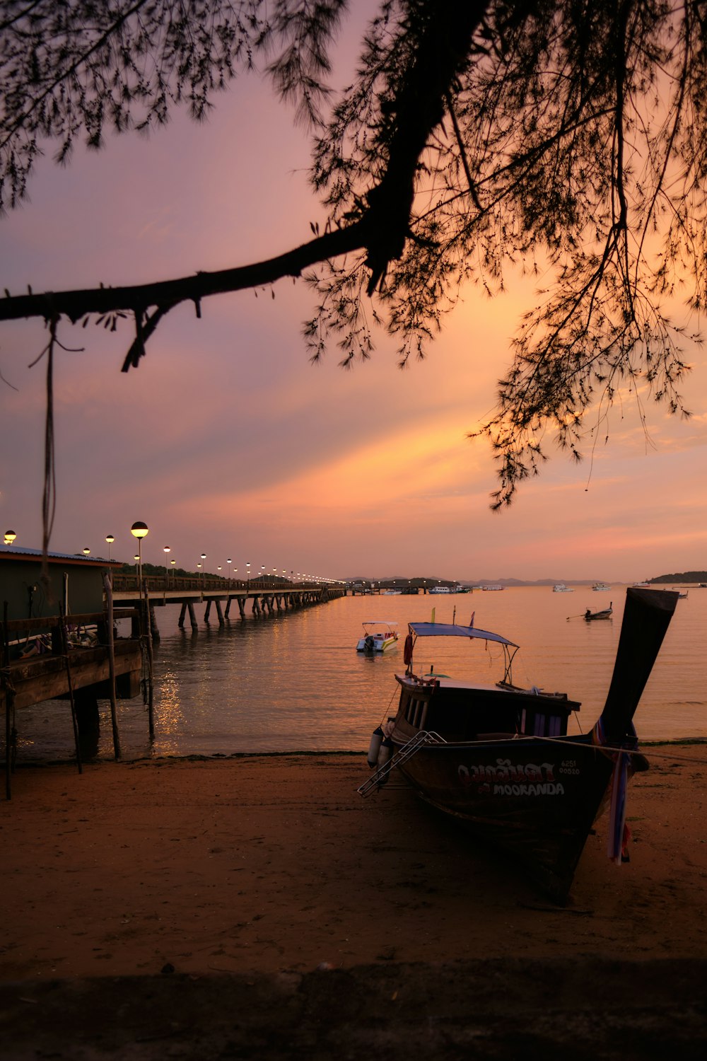 a boat sits on the shore of a lake